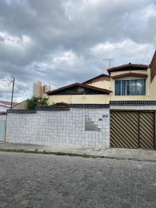 a house on the side of a street with a fence at Temporada CG - Cantinho Nordestino in Campina Grande