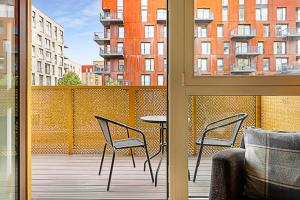 Beautiful Apartment in Surrey Quays في لندن: شرفة مع كرسيين وطاولة على شرفة