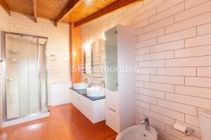 baño con pared de ladrillo blanco y aseo en Luxury appartment 10 minutes from Thessaloniki ,for 8-23 people and gatherings en Néon Rýsion