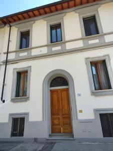 a white building with a wooden door and windows at Affittacamere Ramazzini in Florence