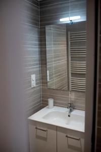 un baño con lavabo y espejo en Au Coeur du Village Bassillac Périgueux, en Bassillac