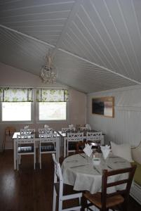 a dining room with tables and chairs and a chandelier at Haltinmaa Cottages in Kilpisjärvi +45 photos