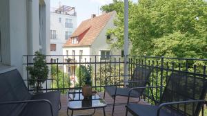 einen Balkon mit Stühlen, einem Tisch und einem Gebäude in der Unterkunft Heger Tor Apartments in Osnabrück