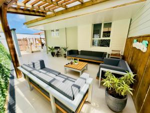 un patio con 2 sofás y una mesa en Sublime Villa Piscine - Trésor de la Baie, en La Trinité