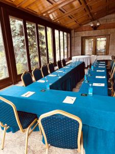 una fila de mesas en una habitación con mesas y sillas azules en Palacio de Miraflores en Miraflores de la Sierra