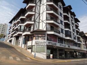 a tall white building on the corner of a street at Encantos da Morada do Sol in Piratuba