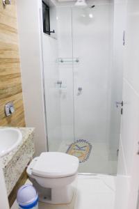 ein weißes Bad mit einem WC und einer Dusche in der Unterkunft Encantos da Morada do Sol in Piratuba