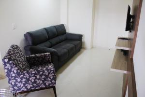a living room with a couch and a chair at Encantos da Morada do Sol in Piratuba