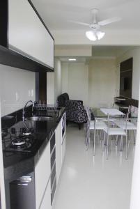 eine Küche und ein Esszimmer mit einem Tisch und Stühlen in der Unterkunft Encantos da Morada do Sol in Piratuba