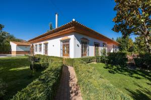 巴薩的住宿－Alojamiento rural de lujo，一座白色的小房子,拥有郁郁葱葱的绿色庭院