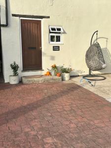 a front door of a house with plants and a chair at Beautiful Cottage by The River Trent in Dunham