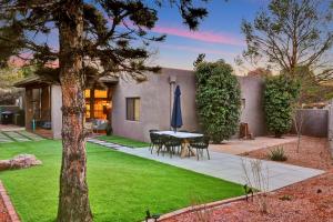 a patio with a table and a blue umbrella at Three Bedroom, Amazing Views, Hot Tub and Pets Allowed, Close to Chapel of the Holy Cross and Chapel Hill, less than 1mi to Trailheads in Sedona