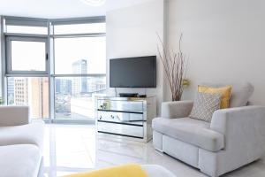 a living room with a tv and a couch and a chair at Luxury Cardiff City Centre Apartments in Cardiff