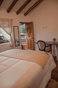een slaapkamer met een bed, een tafel en een raam bij Casa Faustina - Pisac in Cuzco
