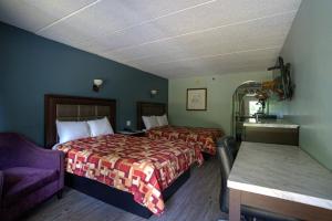 a hotel room with two beds and a table at Excel Inn & Suites in Fredericksburg
