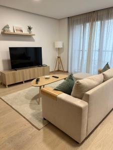 sala de estar con sofá y TV en Move in Miragaia, en Vigo