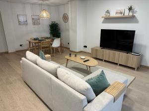 a living room with a couch and a tv and a table at Move in Miragaia in Vigo