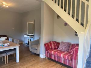 ein Wohnzimmer mit einem Sofa und einer Treppe in der Unterkunft Victoria's Countryside Apartment in Mallow
