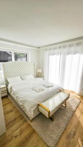 1 dormitorio blanco con 1 cama grande y 2 ventanas en Luxus Neubau 65m2 City Wohnung - L, en Múnich