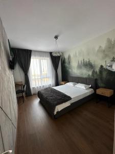 - une chambre avec un lit et une peinture murale dans l'établissement Atractiv Apartaments, à Chiajna