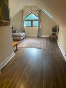 sala de estar vacía con ventana grande y suelo de madera en Victoria's Countryside Apartment, en Mallow