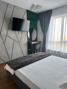 a bedroom with a bed with a tv on the wall at Atractiv Apartaments in Chiajna