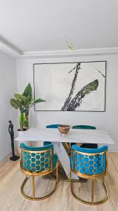 una mesa blanca y 2 sillas azules en una habitación en Luxus Neubau 65m2 City Wohnung - L, en Múnich