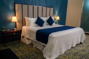a bedroom with a large bed with blue walls at HOTEL MARGARITA in Puebla
