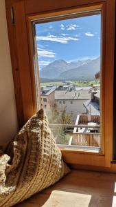 a window with a view of a mountain view at Weisses Kreuz - Crusch Alva in Samedan