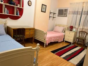 a bedroom with two beds and a desk and a dresser at Lovely furnished 2-bedroom apartment with balcony in Cairo