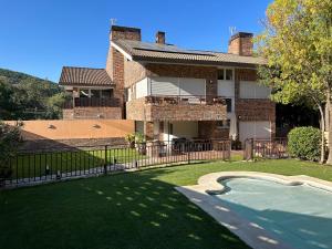 a house with a swimming pool in the yard at CASA VILLACERRADA in Navacerrada