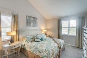 a bedroom with a bed and a table and two windows at Coastal St Simons Retreat Near Gascoigne Bluff! in Saint Simon Mills