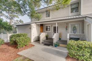 a white house with a porch and a driveway at Coastal St Simons Retreat Near Gascoigne Bluff! in Saint Simon Mills