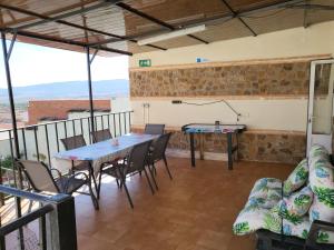 Cette chambre dispose d'un balcon avec une table et des chaises. dans l'établissement Casa Rural Oasis, una casa rural en Puertollano, agradable, con Piscina en zona tranquila, à Puertollano