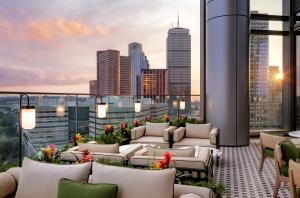 a rooftop patio with couches and a view of the city at Raffles Boston in Boston