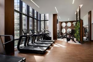 a row of treadmills in a gym with large windows at Raffles Boston in Boston