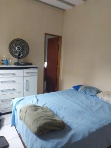 a bedroom with a bed and a dresser and a fan at Casa de férias in Conceição da Barra