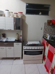 a small kitchen with a stove and a counter at Casa de férias in Conceição da Barra