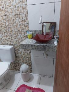 a bathroom with a toilet and a counter with a sink at Casa de férias in Conceição da Barra