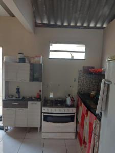 a kitchen with a stove and a counter top at Casa de férias in Conceição da Barra