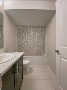 Baño blanco con aseo y lavamanos en Fully Furnished En-Suite Basement, en Ottawa