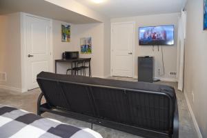 Habitación con cama y TV en la pared. en Fully Furnished En-Suite Basement, en Ottawa