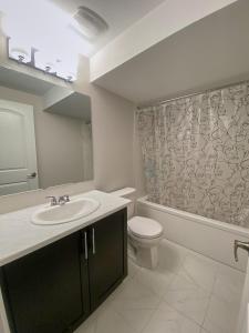 bagno con lavandino, servizi igienici e specchio di Fully Furnished En-Suite Basement a Ottawa