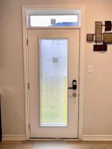 a white door with a window in a room at Fully Furnished En-Suite Basement in Ottawa