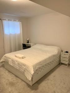 Un pat sau paturi într-o cameră la Fully Furnished En-Suite Basement