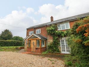 a brick house with a porch on the side of it at Frosthill Cottage in Newport