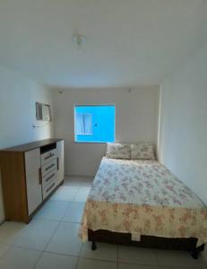 a bedroom with a bed and a dresser at Apart. 2/4 - 500 mts da praia.Ilhéus in Ilhéus
