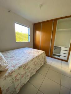 Schlafzimmer mit einem Bett und einem Fenster in der Unterkunft Apart. 2/4 - 500 mts da praia.Ilhéus in Ilhéus