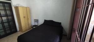 1 dormitorio con 1 cama negra en una habitación en Quarto em casa a 1.4km da UFSM, en Santa Maria