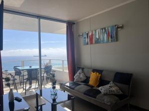 a living room with a couch and a view of the ocean at costa mansa 3200 in Coquimbo